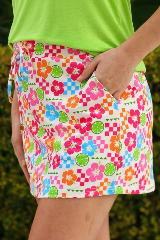 Colorful patterned skirt worn by a person with a green top against a blurred natural background
