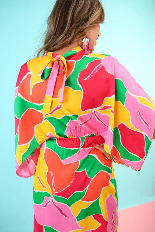 Colorful floral kimono with pink accents on a light blue background