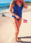 Woman in a blue swimsuit on a beach with a clear sky