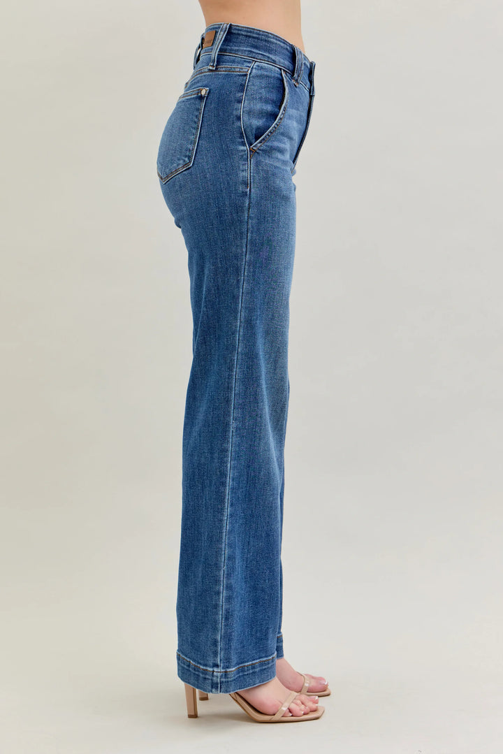 Blue jeans worn by a person on a plain background