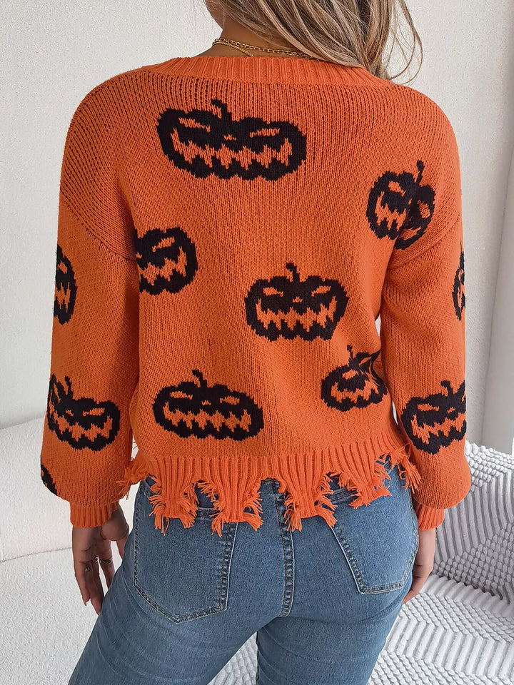 Women wearing orange sweater with black pumpkins on it while facing a wall