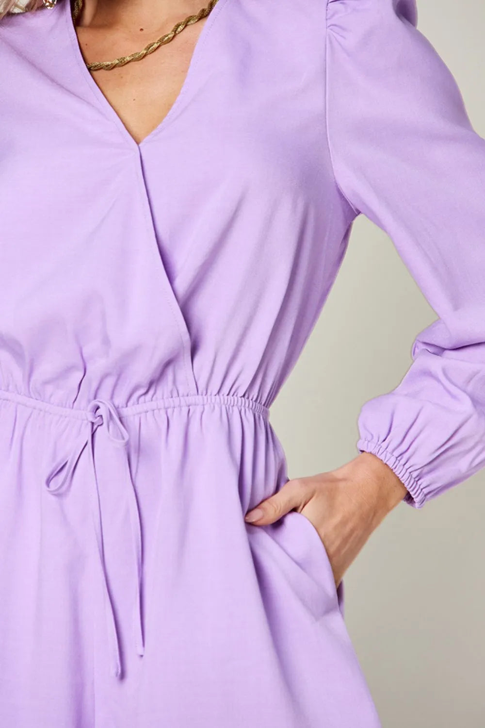 Purple dress with long sleeves on a plain background