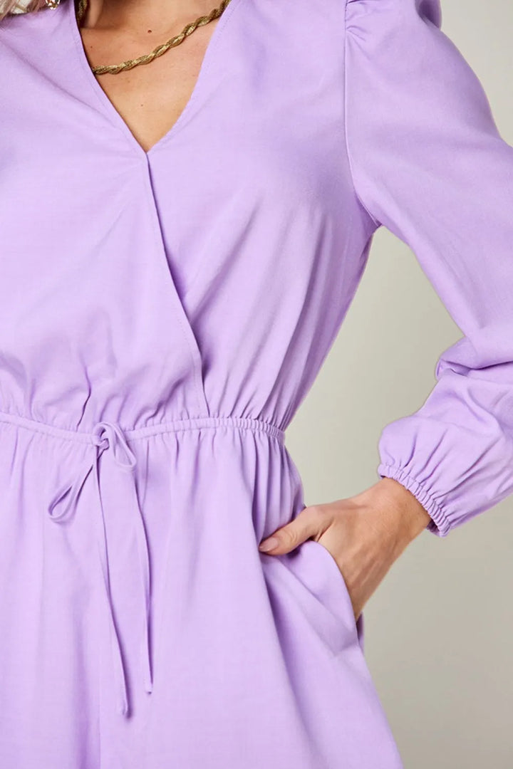Purple dress with long sleeves on a plain background