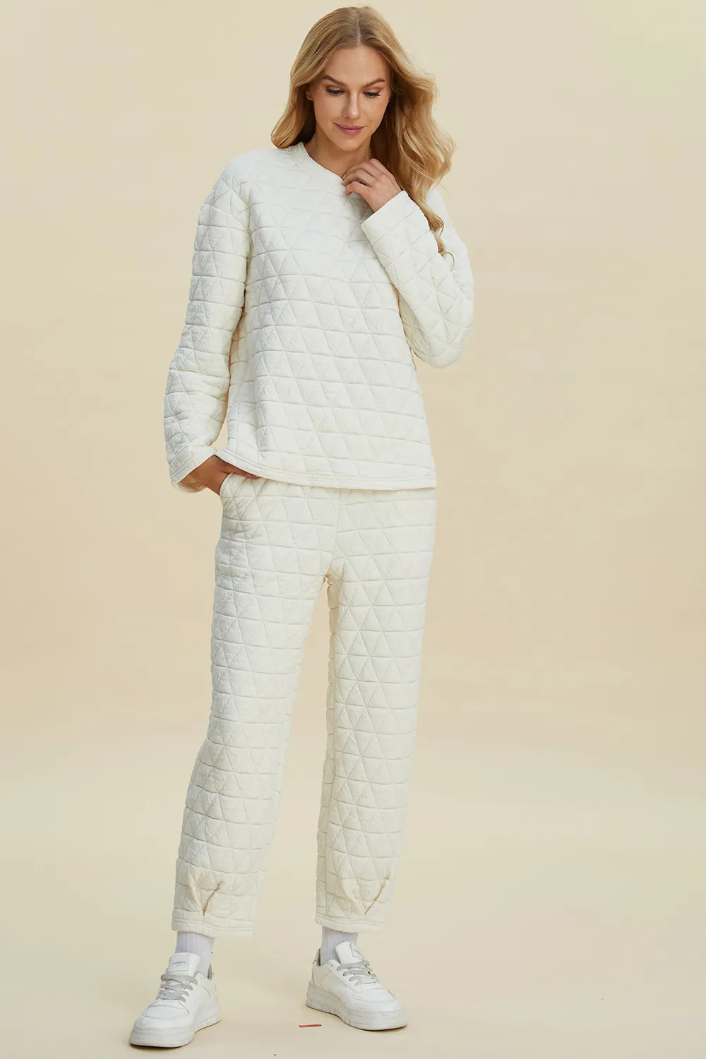 Woman wearing a matching quilted outfit with a beige background