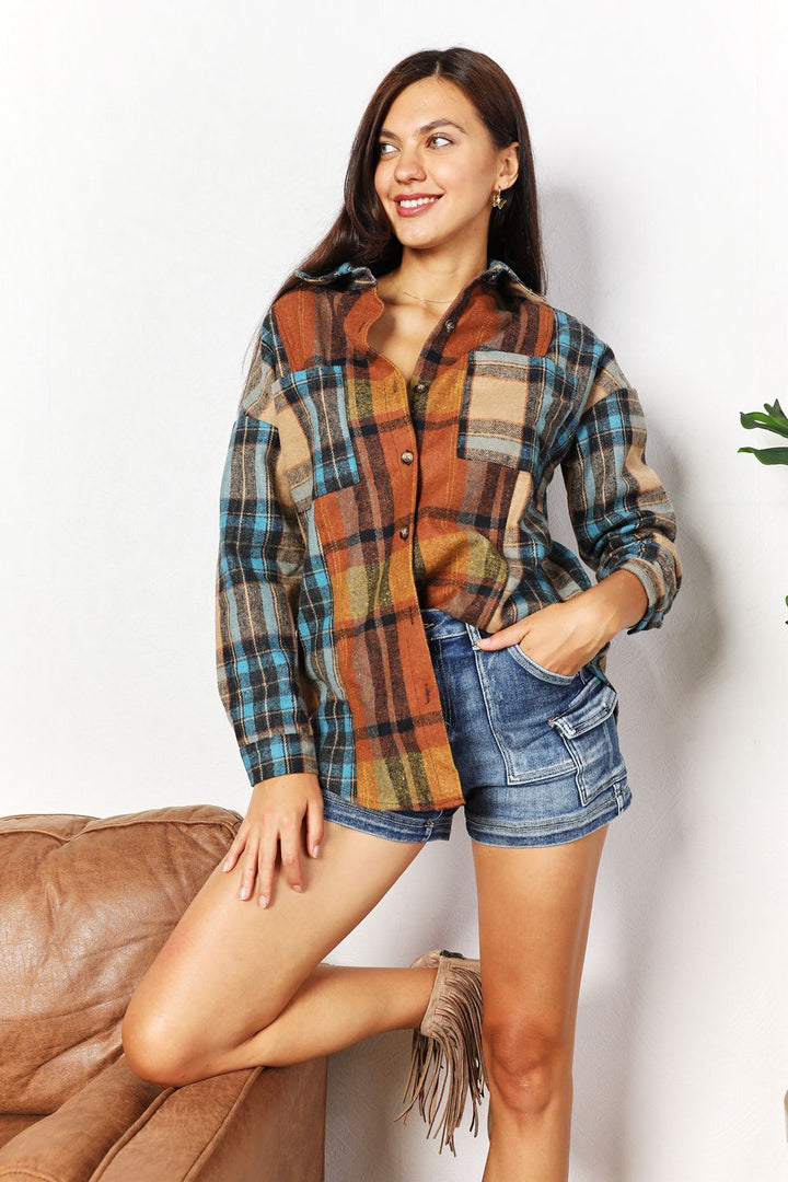 Woman wearing a plaid shirt and denim shorts against a white background