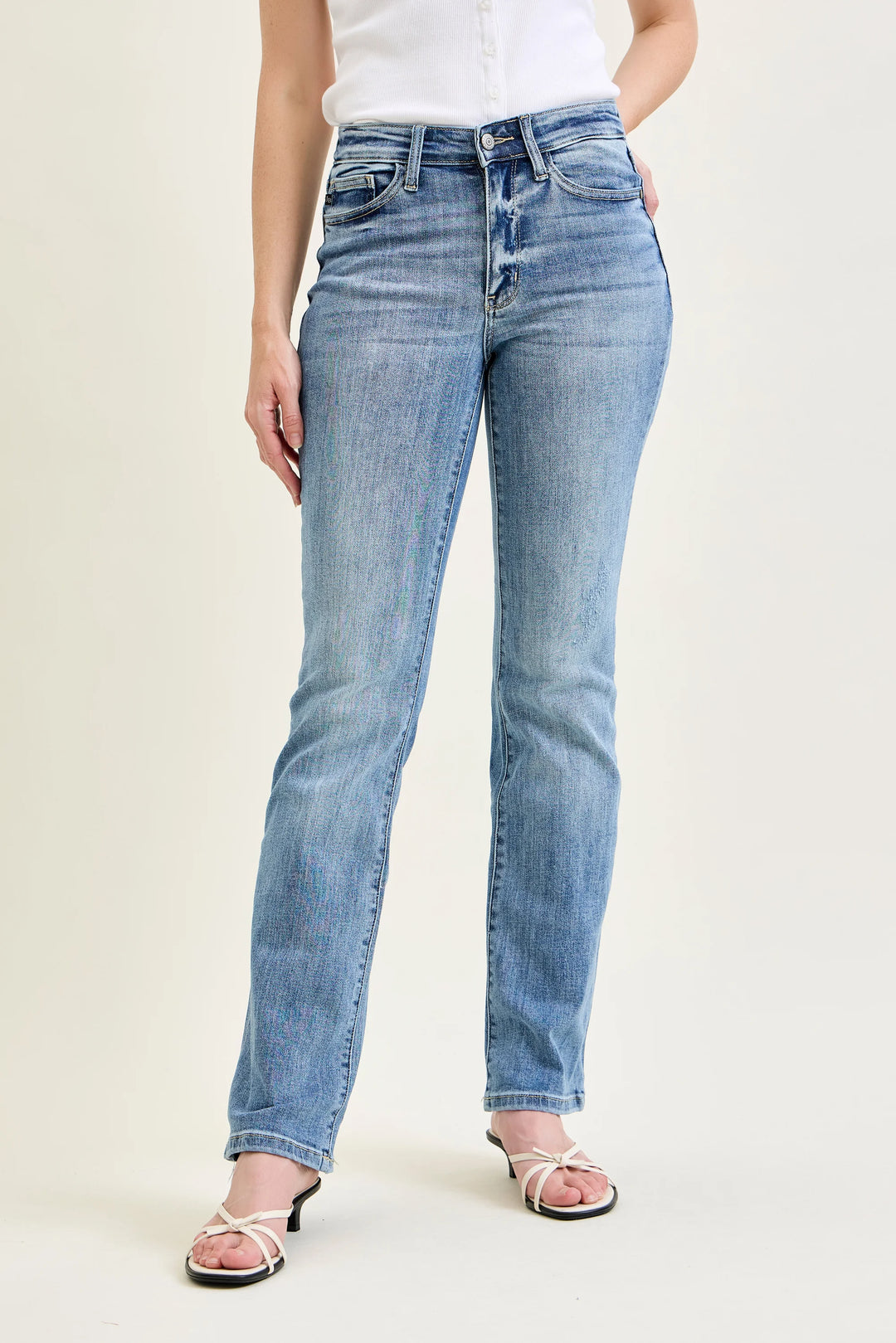Person wearing light blue jeans on a plain background