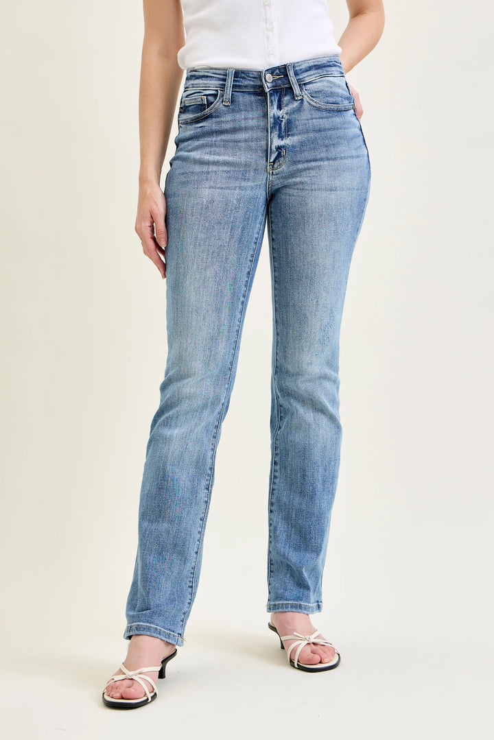 Person wearing light blue jeans on a plain background