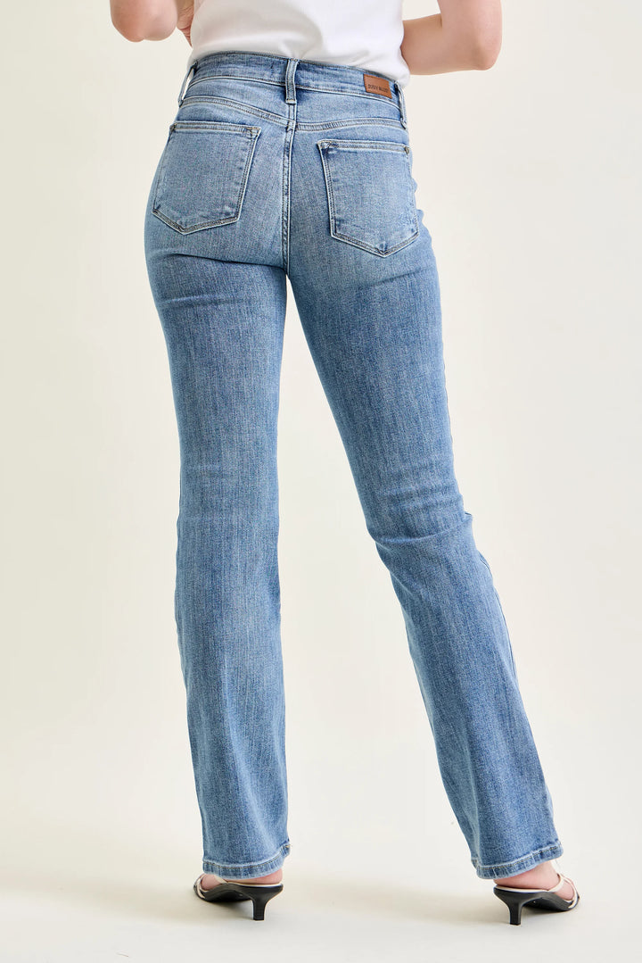 Person wearing blue jeans on a plain background