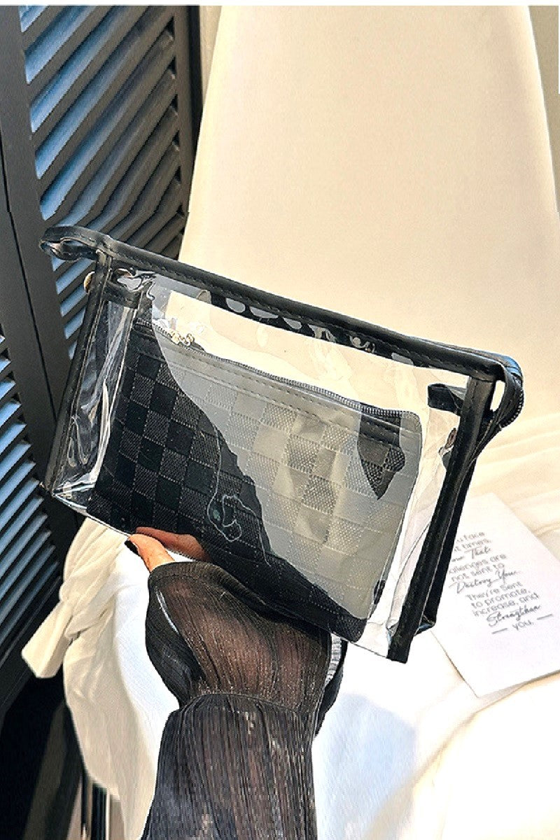 Clear plastic bag with black textured pouch held by a person wearing gloves.