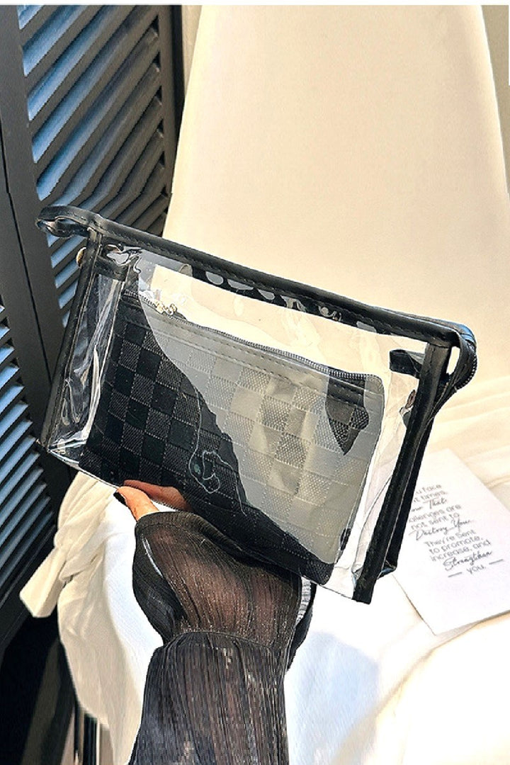 Clear plastic bag with black textured pouch held by a person wearing gloves.