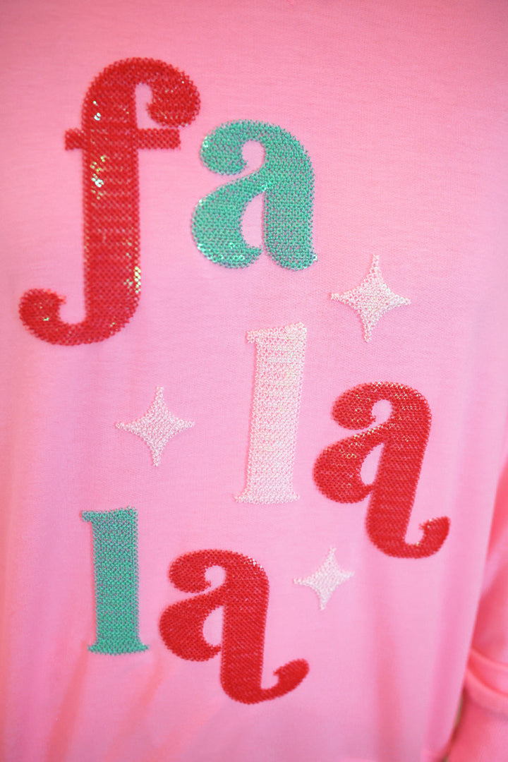 A close-up of a pink sequined sweatshirt featuring the word &