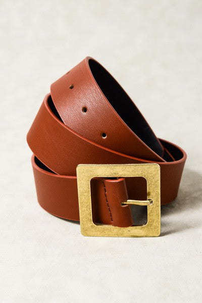 Brown leather belt with a gold buckle on a light gray background