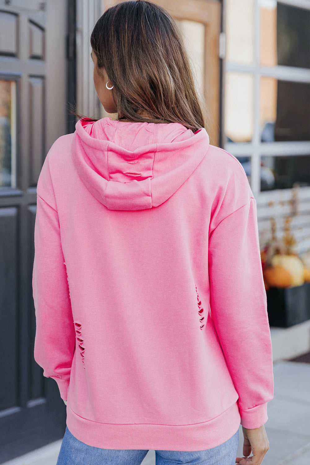 Person wearing a pink hoodie with a blurred background