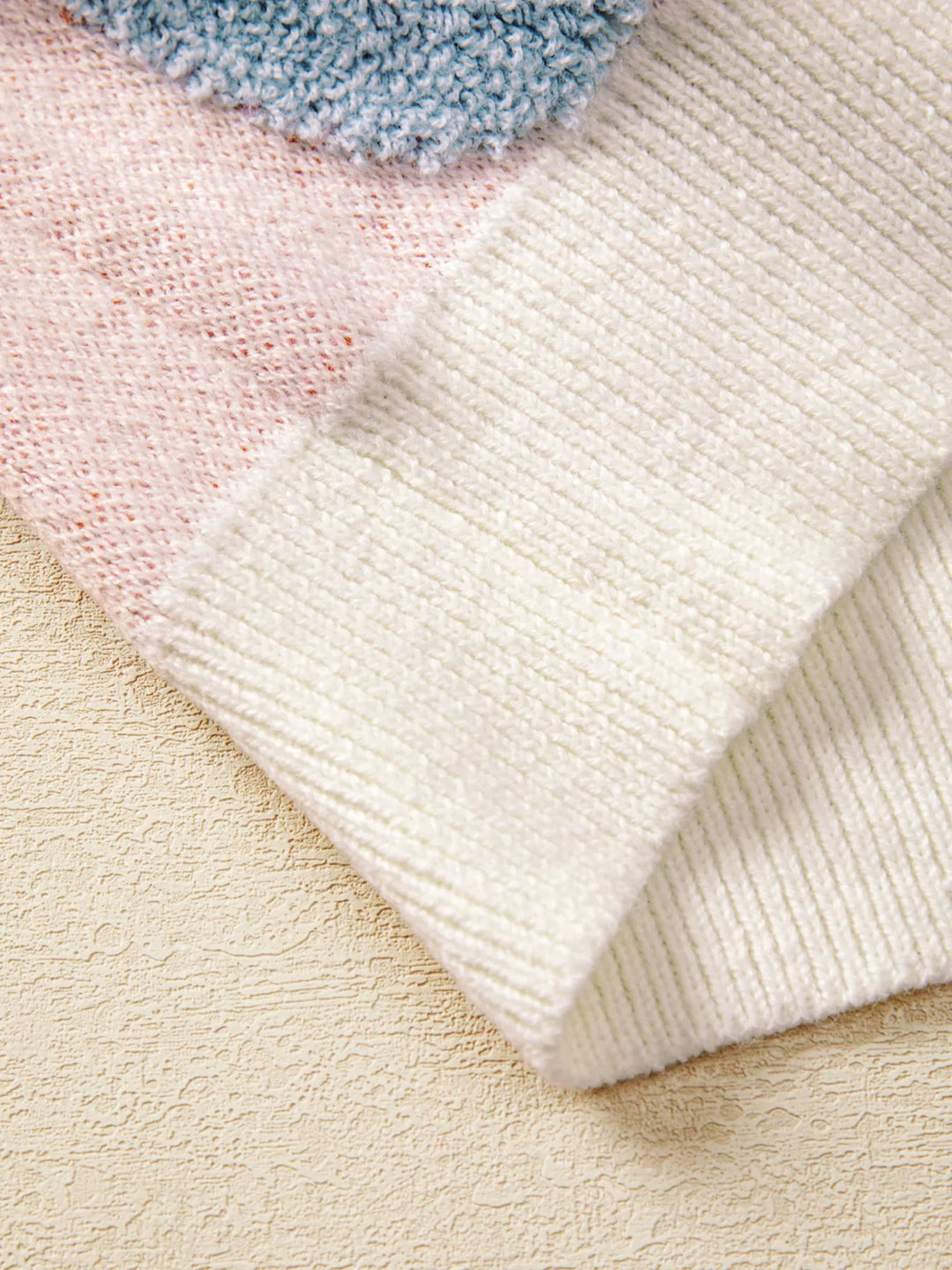A zoomed in picture of the white bottom of the sweater