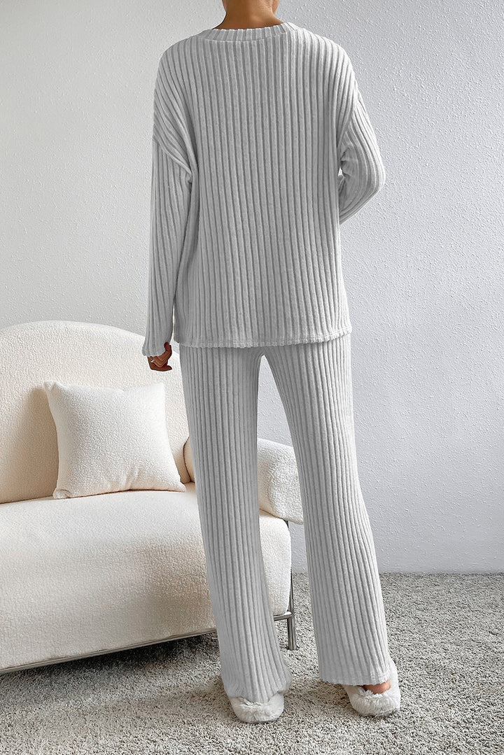 Person wearing a gray ribbed lounge set in a living room setting.