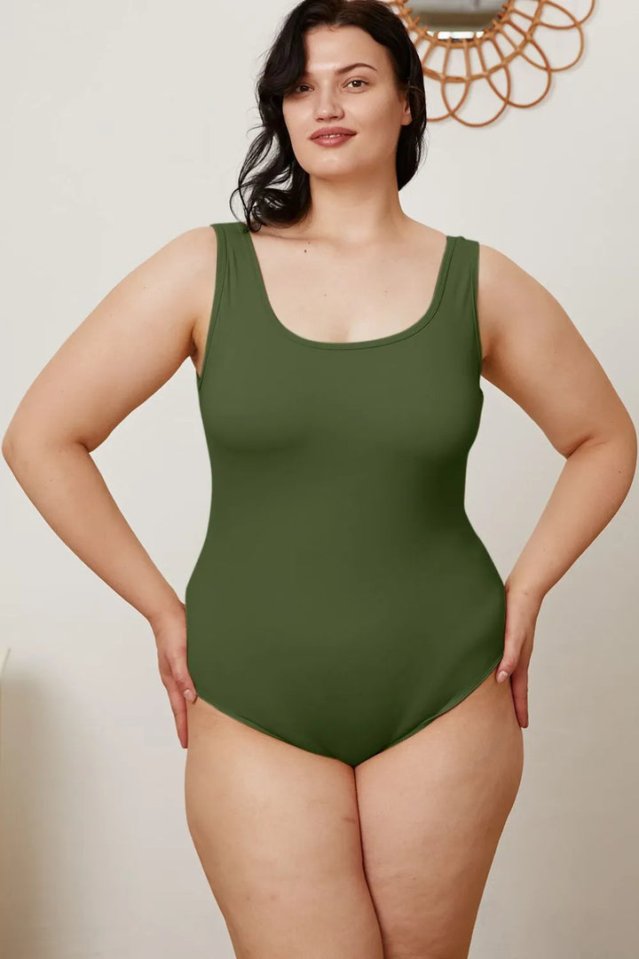 Woman wearing a green swimsuit against a plain background