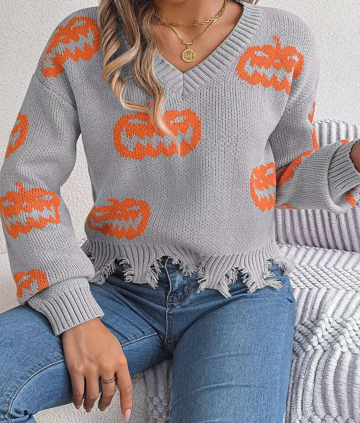 Women wearing grey sweater with pumpkins on it while sitting