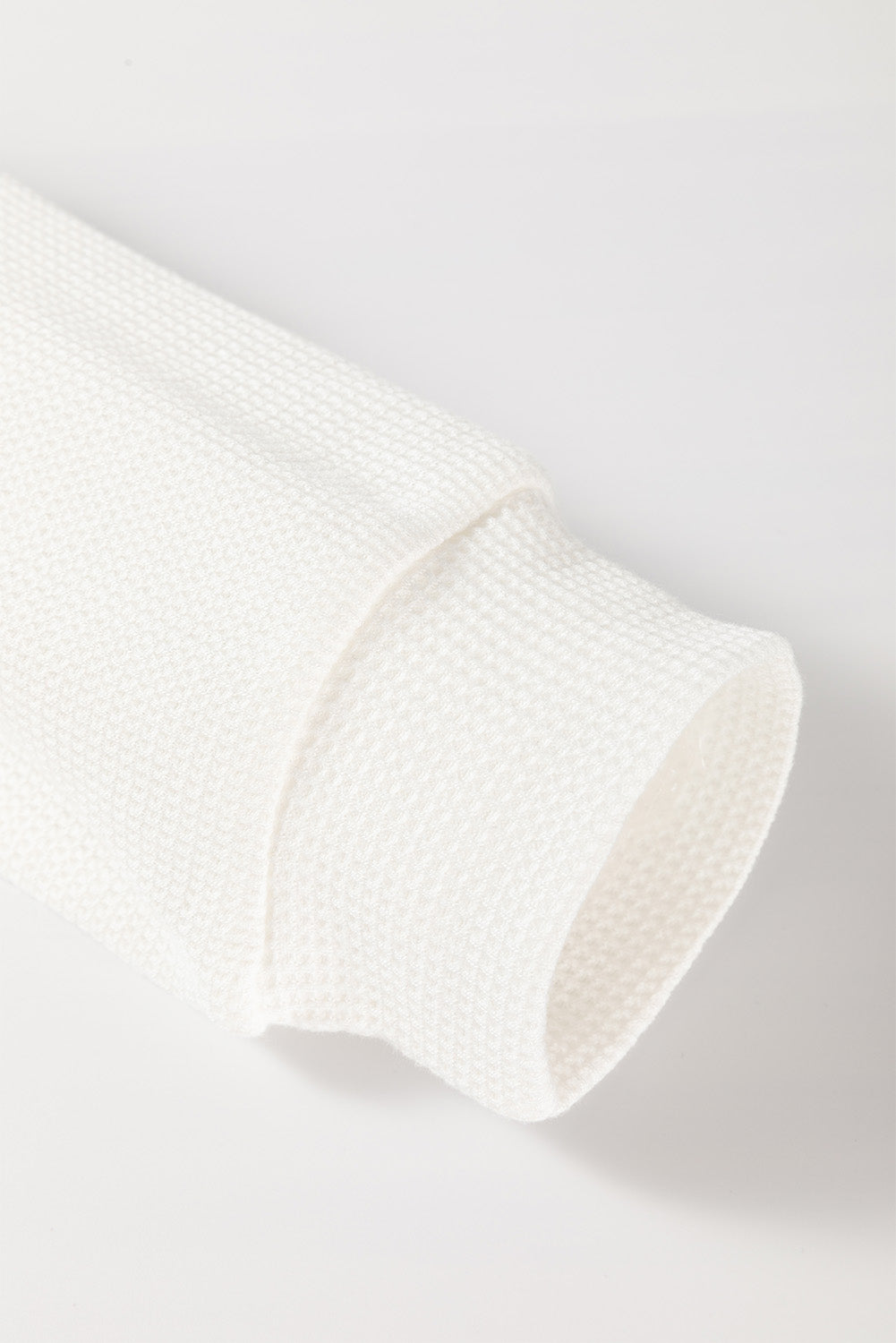 Close-up of a textured white fabric on a light gray background