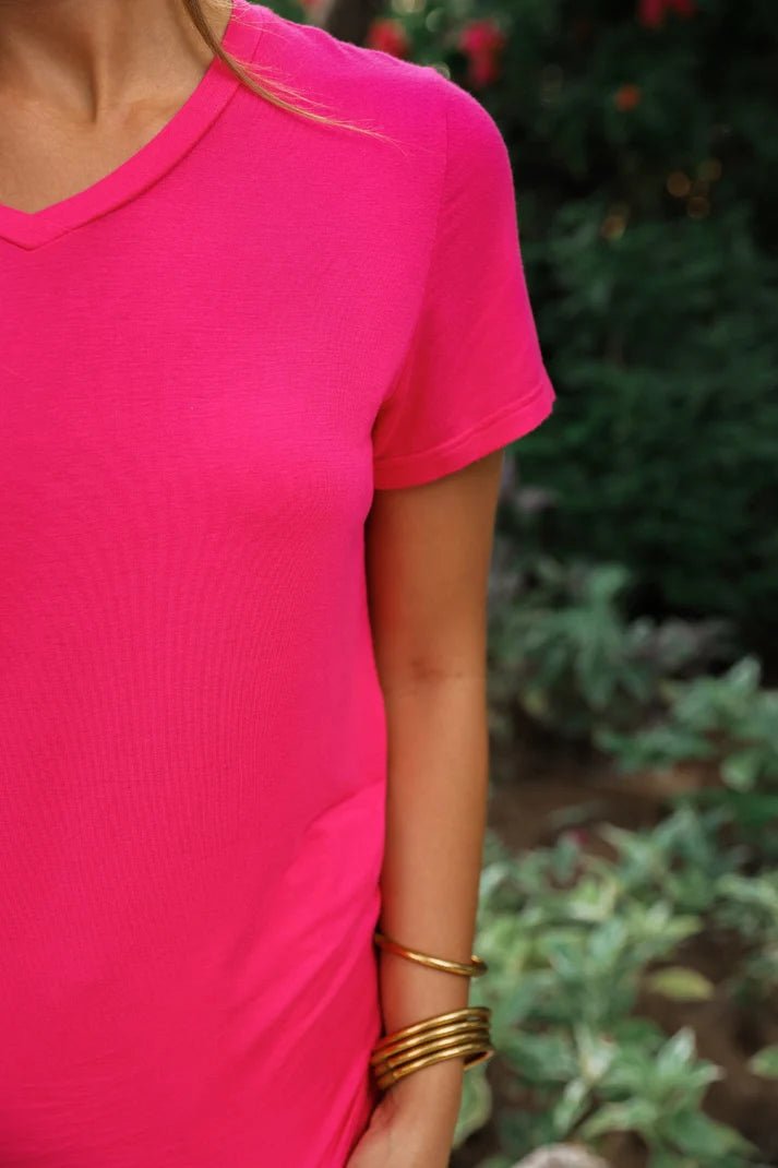 Woman wearing a hot pink, v neck tee.