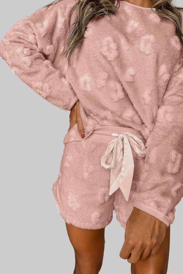 Person wearing a pink textured loungewear set with white background