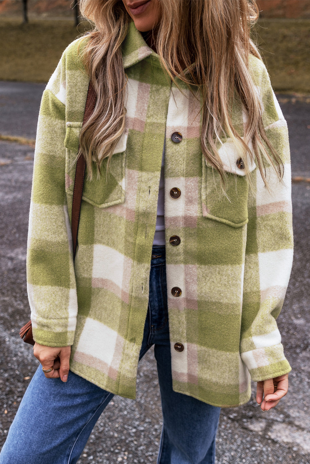 Person wearing a green and white plaid coat with a blurred background