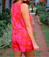 Woman wearing a bright pink floral dress in an outdoor setting