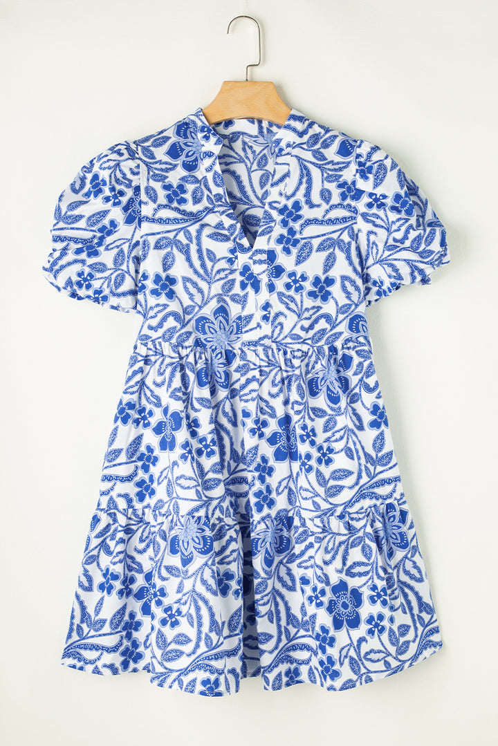 Blue floral dress on a hanger against a white background