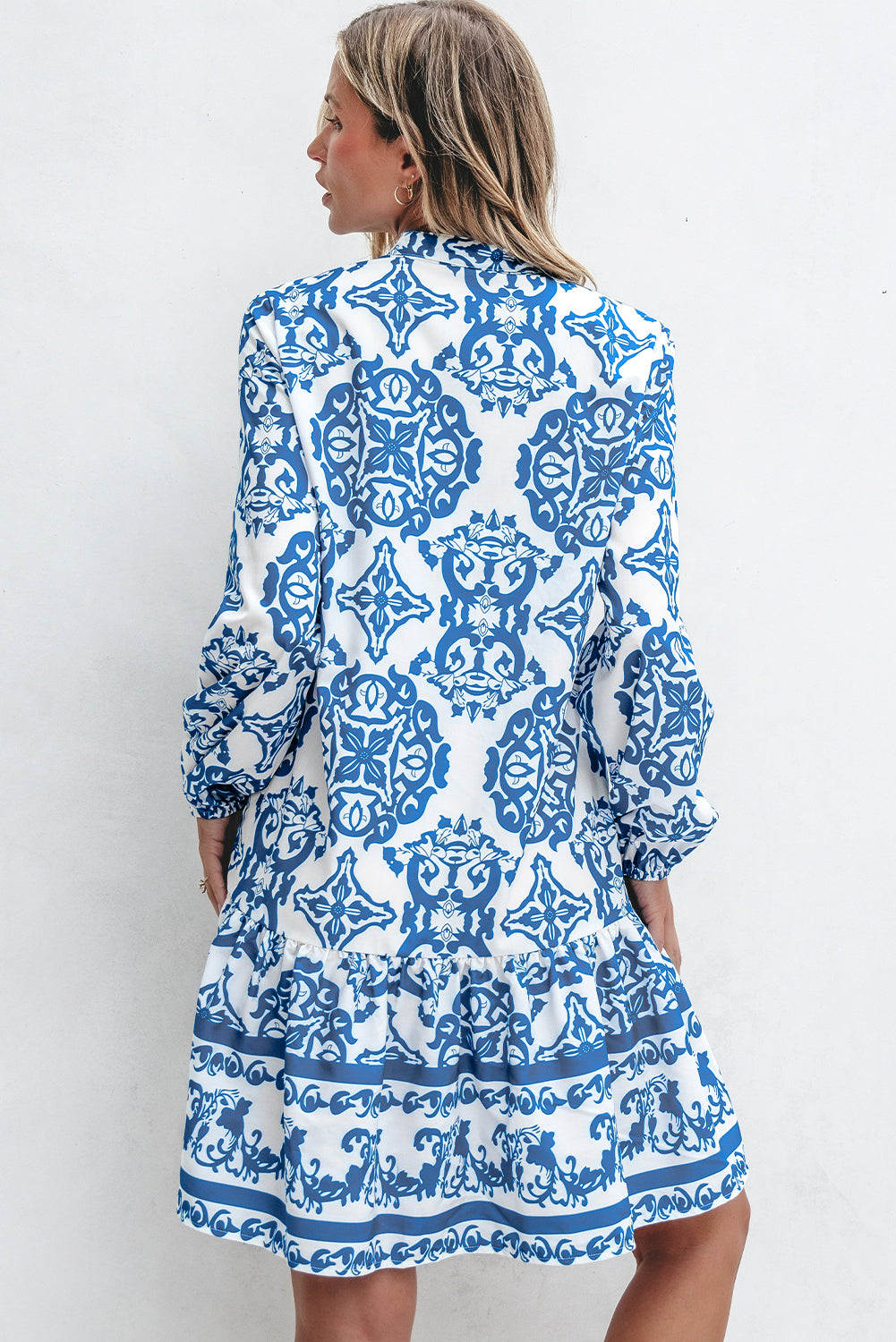 Woman wearing a blue and white patterned dress against a white background