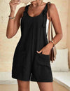 Woman wearing a black romper with a neutral background
