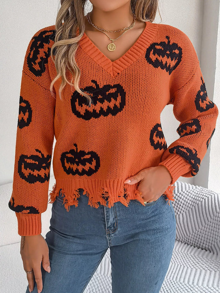 Women wearing orange sweater with black pumpkins on it while hand tucked in right pocket