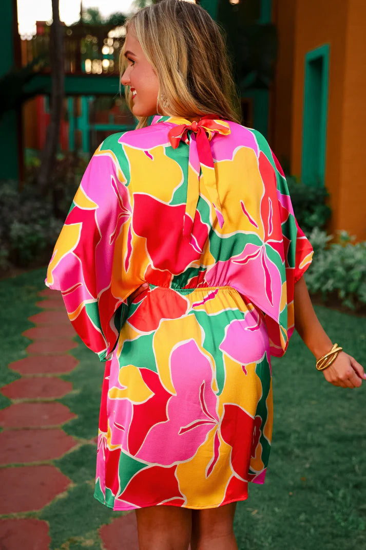 Woman wearing a colorful floral dress in an outdoor setting