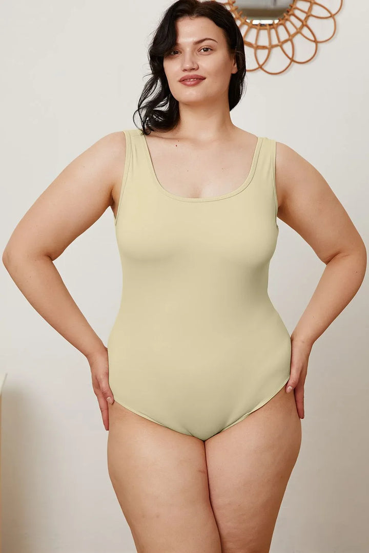 Woman wearing a light green swimsuit against a plain background