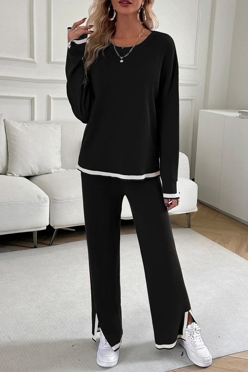 Person wearing a black outfit with white sneakers in a living room setting