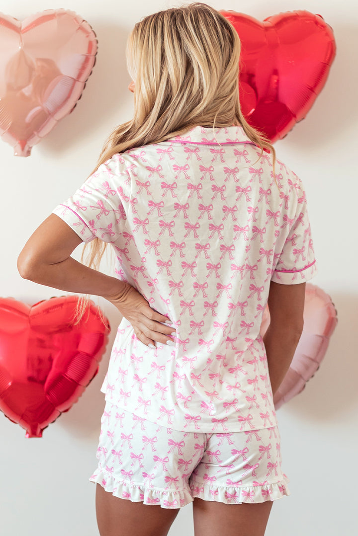 Woman wearing a pink and white pajama set with heart-shaped balloons in the background.