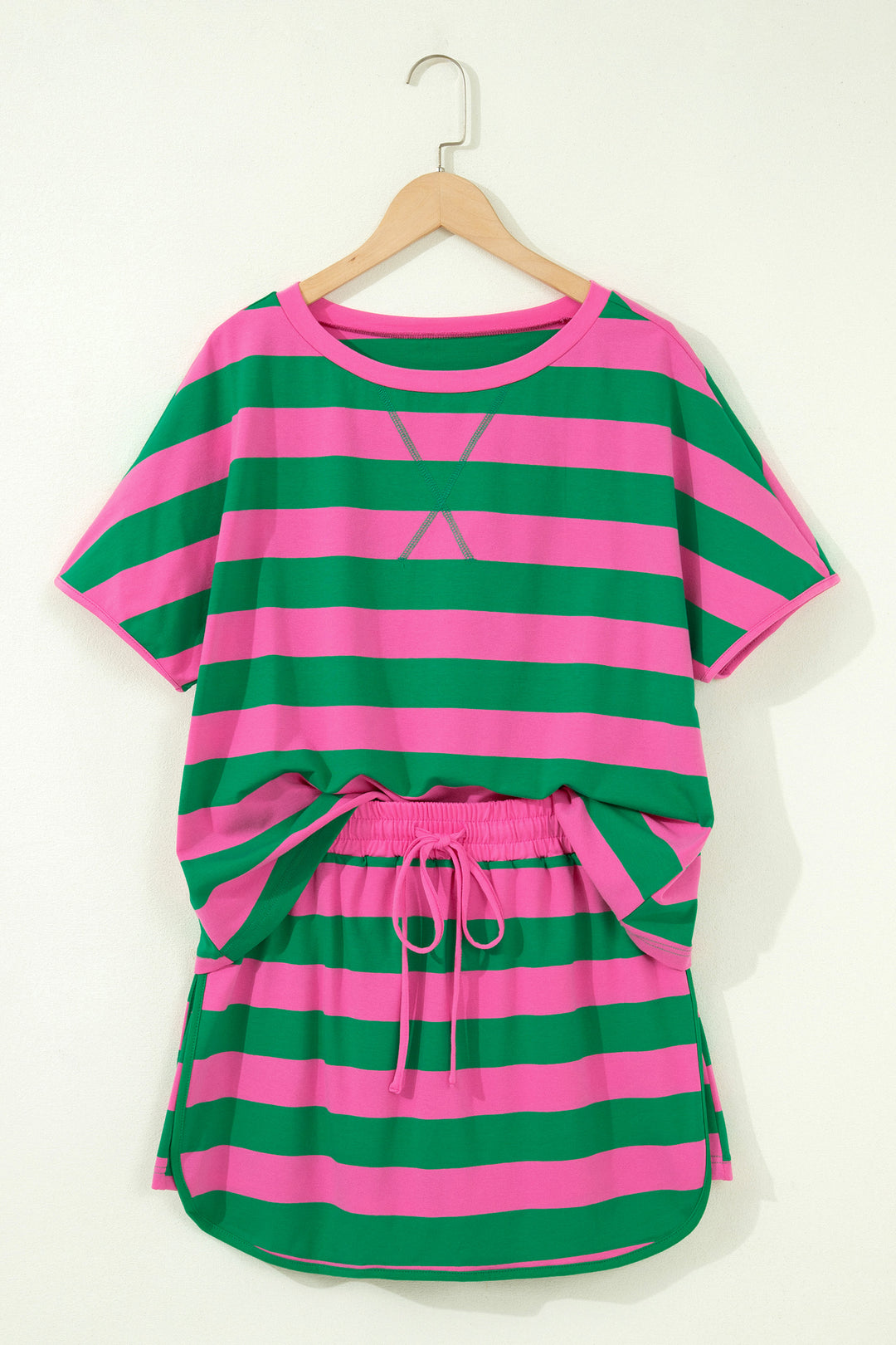 Green and pink striped outfit on a hanger against a white background