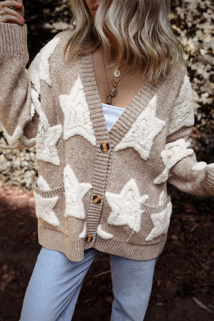 Person wearing a beige cardigan with star patterns outdoors.