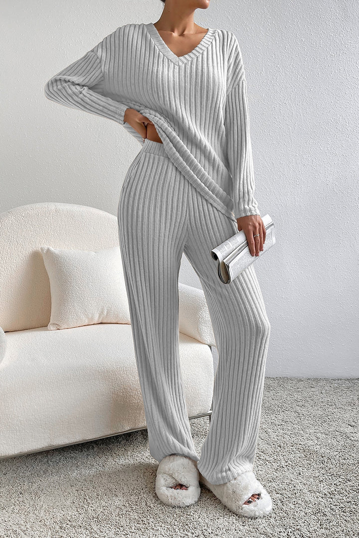 Person wearing a gray ribbed lounge set in a cozy living room.