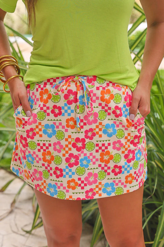Person wearing a colorful floral skirt with a green top against a natural background