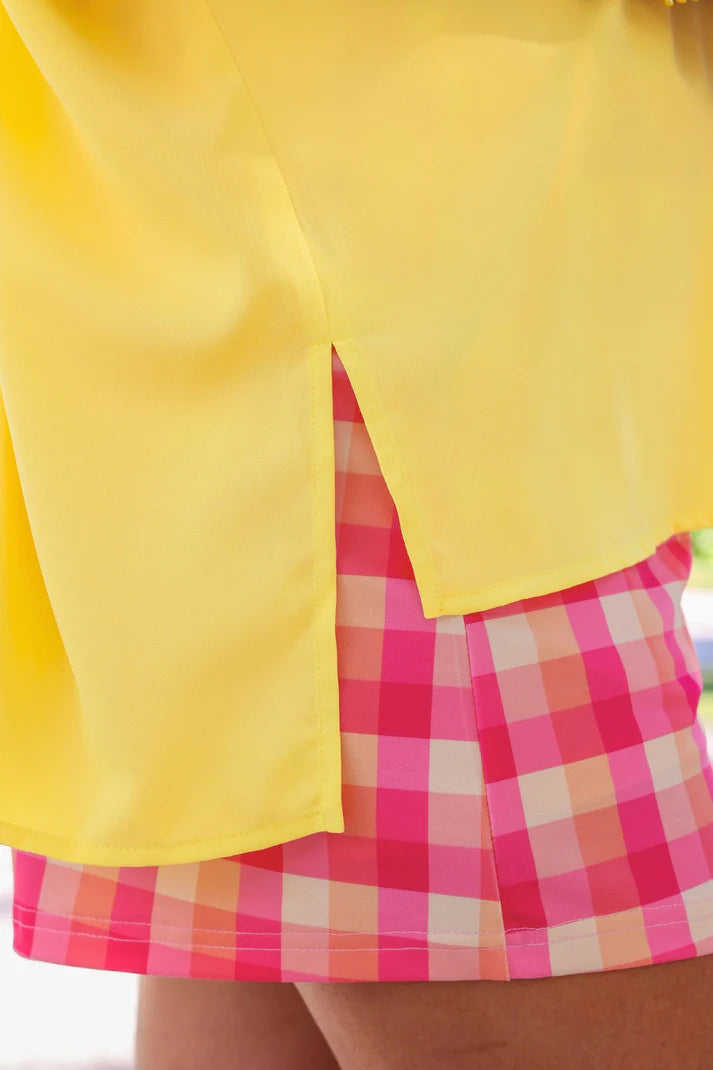 Yellow jacket over a pink checkered skirt