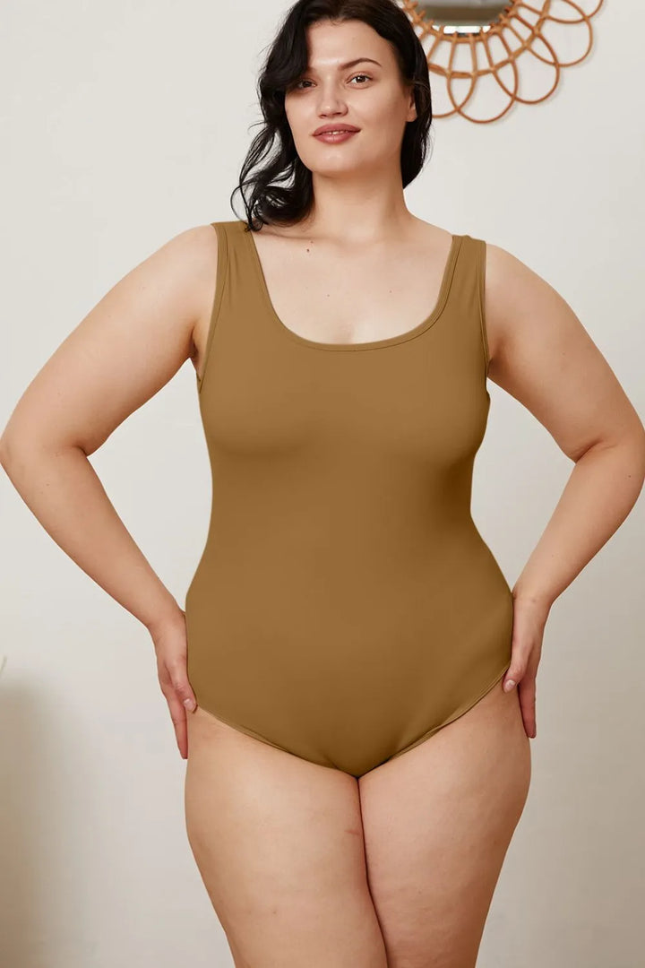 Woman wearing a brown swimsuit against a plain background