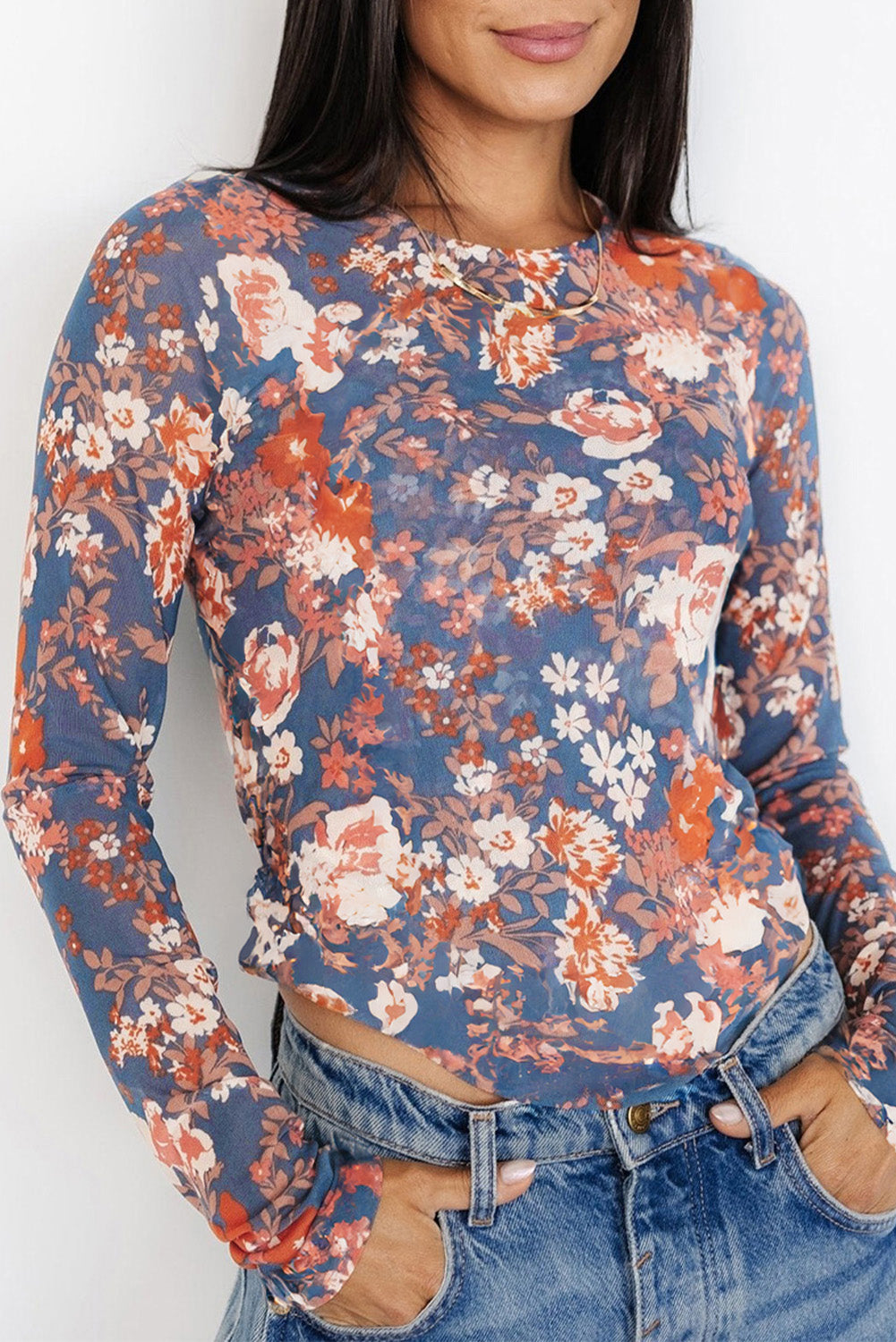 Person wearing a floral long-sleeve top with a white background