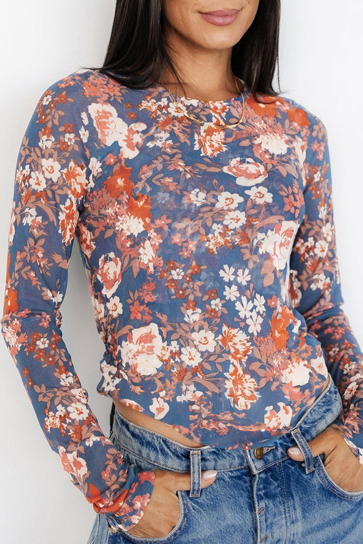 Person wearing a floral long-sleeve top with a white background