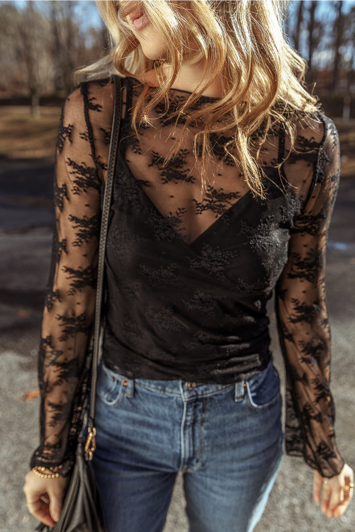 Woman wearing a black lace top and blue jeans outdoors