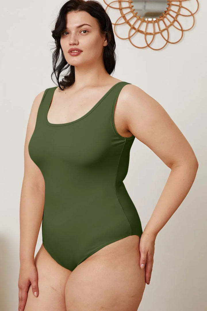 Woman wearing a green swimsuit against a neutral background