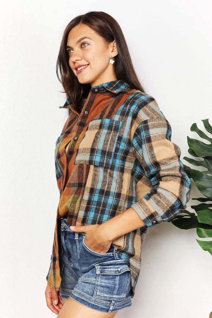 Woman wearing a plaid shirt and denim shorts against a white background