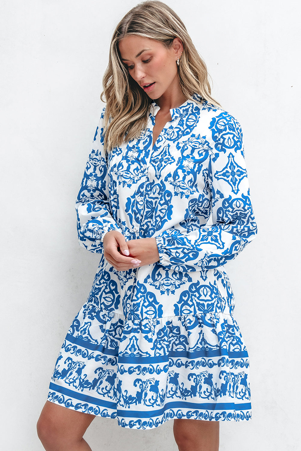 Woman wearing a blue and white patterned dress on a white background