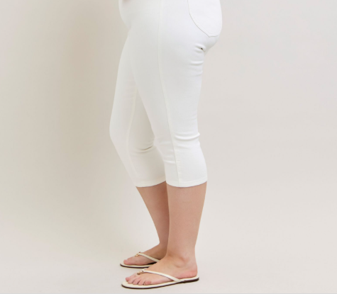 Person wearing white capri pants on a plain background