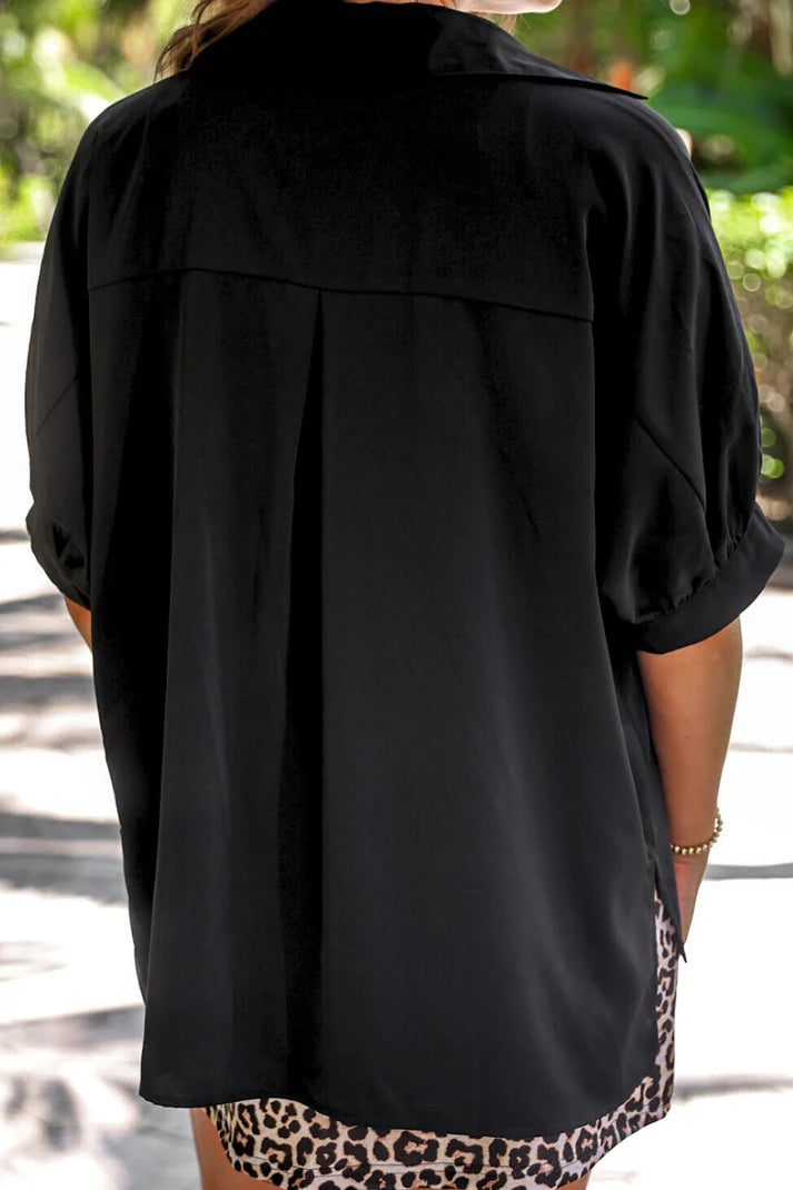 Person wearing a black jacket with leopard print pants outdoors