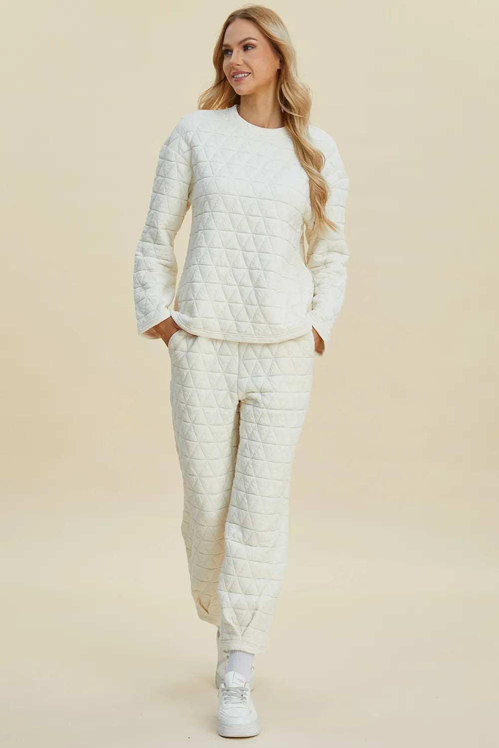 Woman wearing a white quilted outfit on a beige background