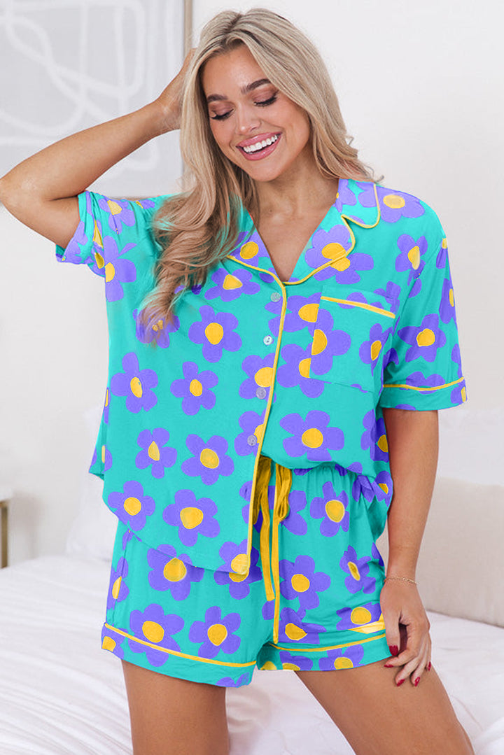 Woman wearing a teal floral pajama set with yellow accents on a white background